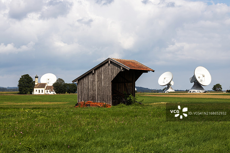 德国巴伐利亚赖斯廷地球站的古老教堂和抛物面天线谷仓图片素材