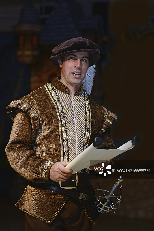 一个穿着中世纪服装的角色正在阅读卷轴图片素材