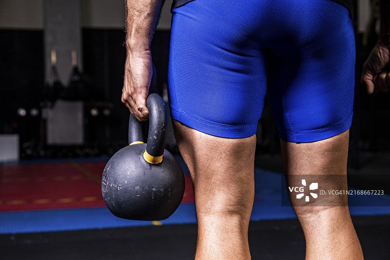 特写：男人在健身房举起重壶铃图片素材
