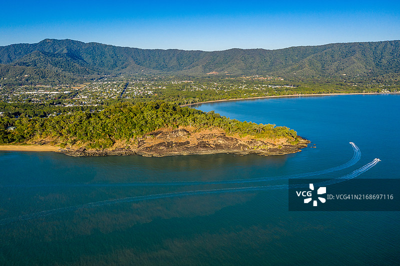 特里尼蒂海滩的葱郁景观与平静水域，船只沿海岸线巡航的航拍图片素材