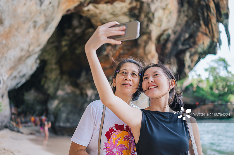 在泰国甲米海滩，母亲和Z世代女儿自拍的温馨时刻图片素材