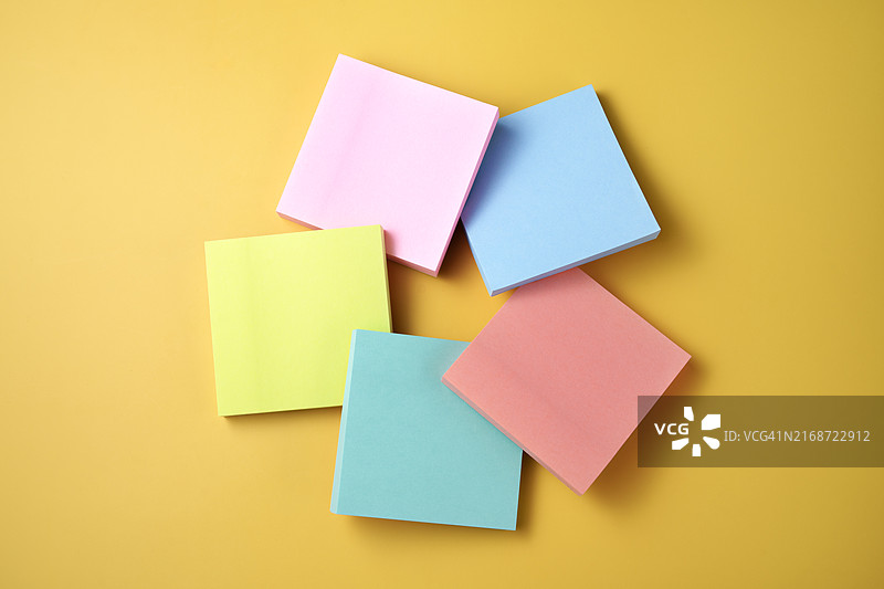 排列在鲜艳彩色背景上的彩色便利贴图片素材