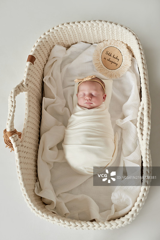 可爱的新生婴儿用白色毯子包裹着。婴儿用品包装模板。脸上带着微笑的新生婴儿特写肖像。健康和医疗概念。图片素材