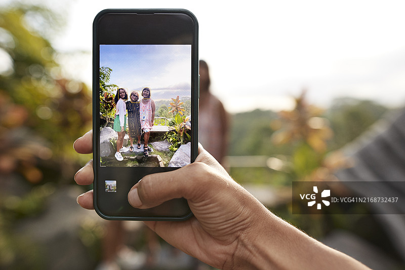 女人用手机拍摄度假中的家人图片素材