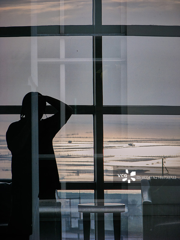 在大型窗户中望向大海的男人轮廓图片素材