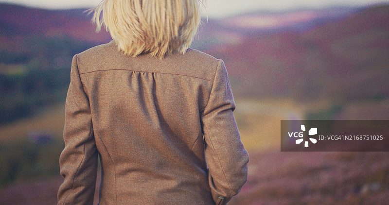 女人走在苏格兰高地的石楠地里图片素材