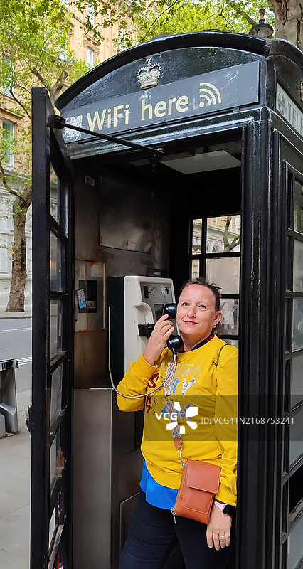 在电话亭里通话的女人图片素材