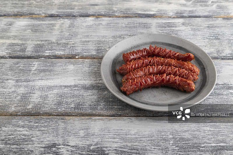灰色木纹背景灰色盘香煎香肠（顶视图，特写，留白）图片素材
