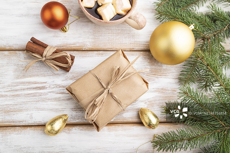 圣诞节或新年作品。装饰品，盒子，金球，肉桂，冷杉和云杉树枝，一杯咖啡，在白色木制背景上。顶部视图，特写，扁平视角图片素材