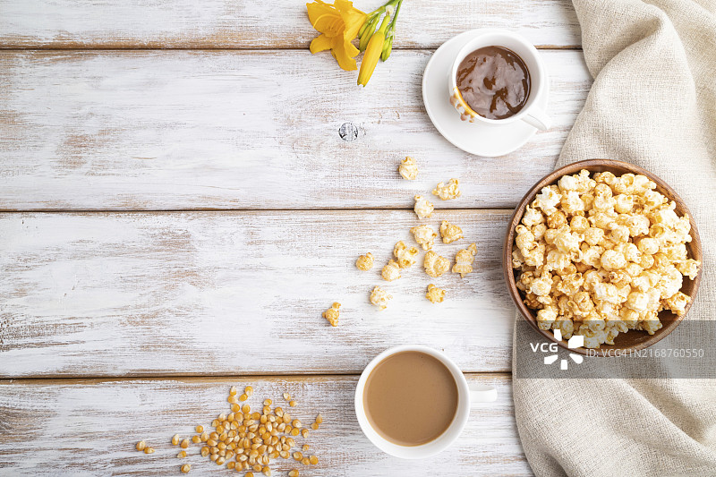 焦糖爆米花、木碗、咖啡与白色木质背景图片素材