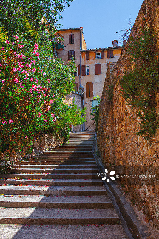 阳光明媚的法国普罗旺斯巴尔若尔小镇石阶，点缀着盛开的夹竹桃图片素材