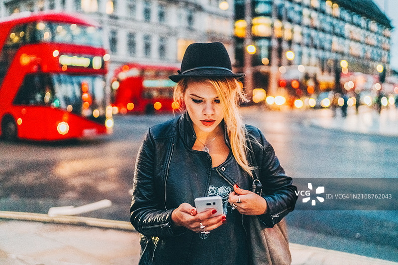 夜晚在伦敦等出租车的女人图片素材