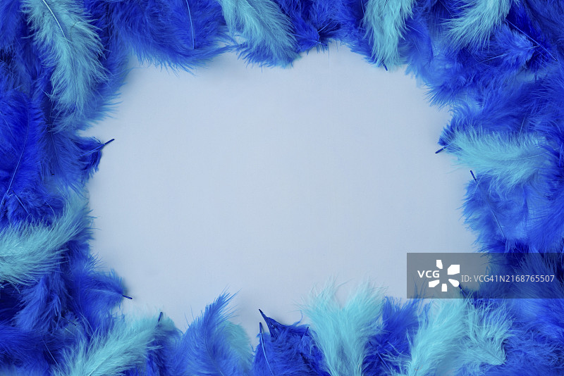 蓝色和蓝绿色羽毛相框，浅蓝色背景图片素材