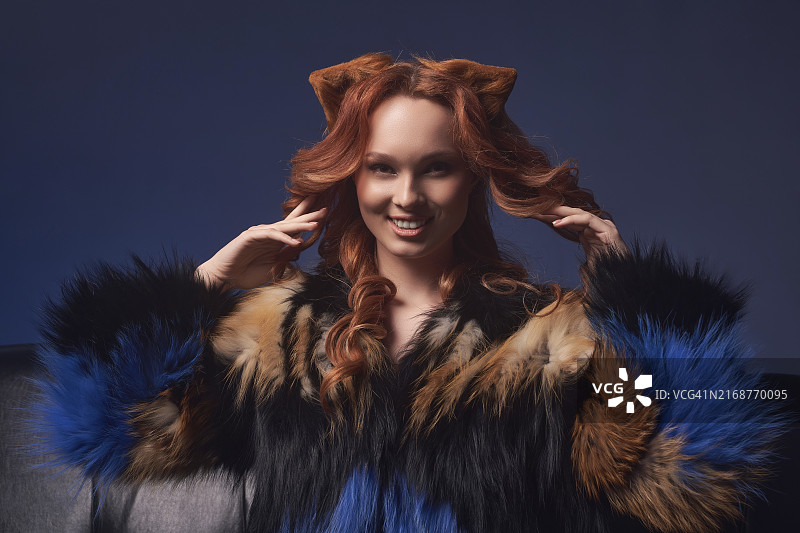 身穿皮草大衣的年轻红发女模特图片素材