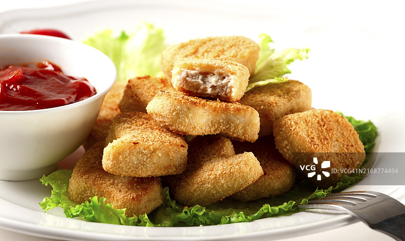 生菜叶上的炸鸡胸块，配以番茄酱图片素材