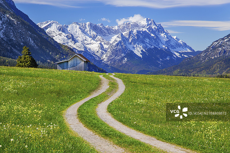 德国巴伐利亚上巴伐利亚蓝色土地埃申洛厄韦特施泰因山脉楚格峰前干草谷仓春季草甸山区小路图片素材