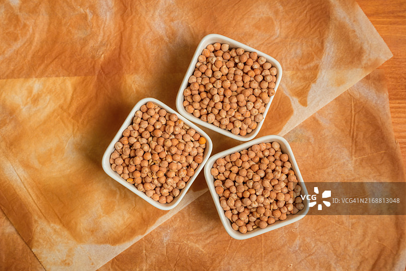 三碗鹰嘴豆配烘焙纸，顶视图图片素材