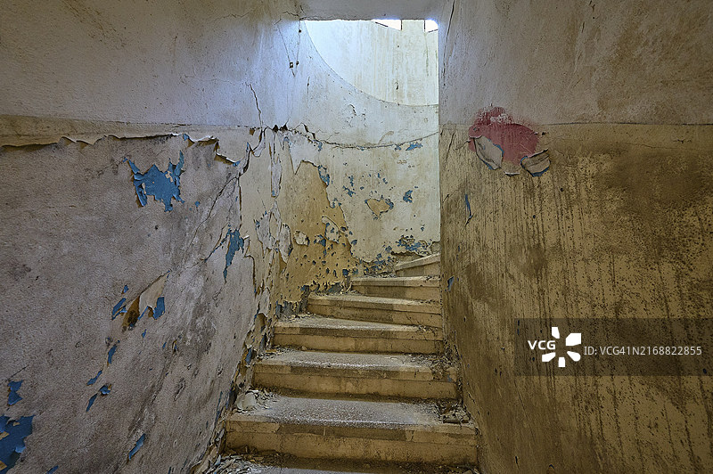 油漆剥落的破旧楼梯,圆形窗户透入光线,废弃之地,前疗养院,1947-1970年结核病中心,前意大利殖民地,埃莱乌萨,坎波基亚罗,罗得岛,十二群岛,希腊,欧洲图片素材