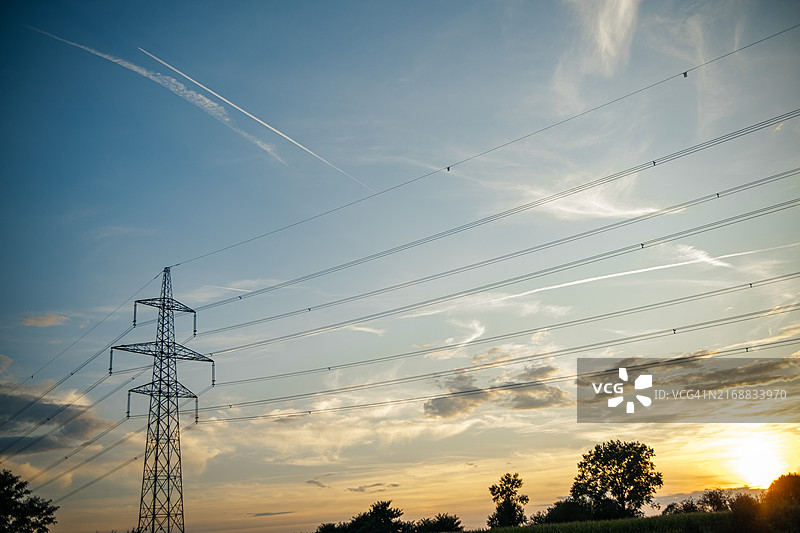 日落时分田野中的高压输电线图片素材