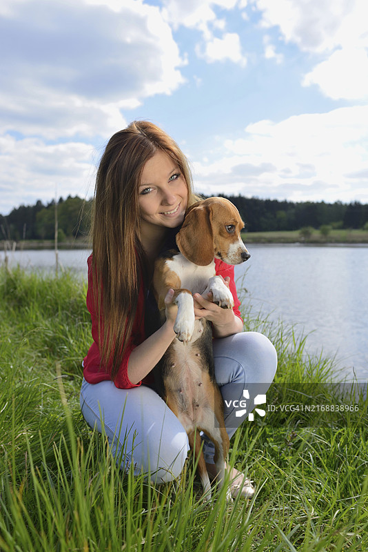 春天，年轻女子和她的比格犬的特写图片素材