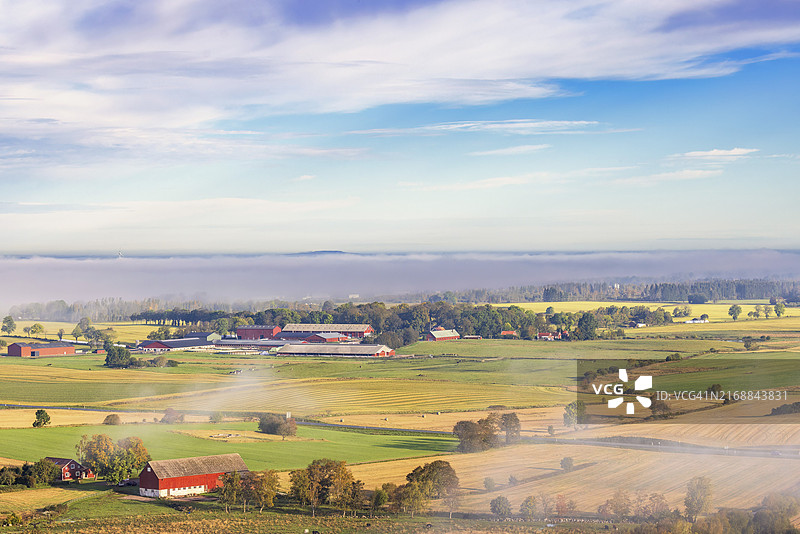 瑞典乡村平原景观：农田与晨雾中的农场图片素材