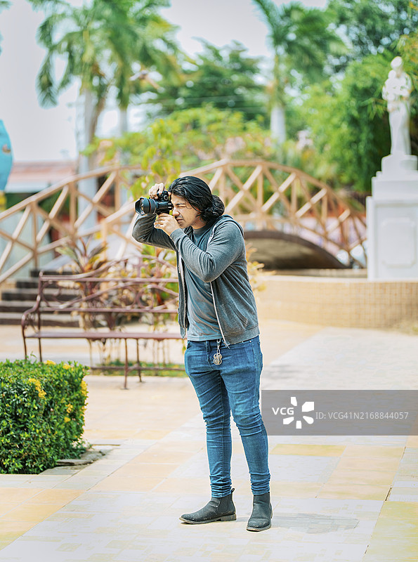 年轻男摄影师在公共公园的街道上拍照，尼加拉瓜图片素材