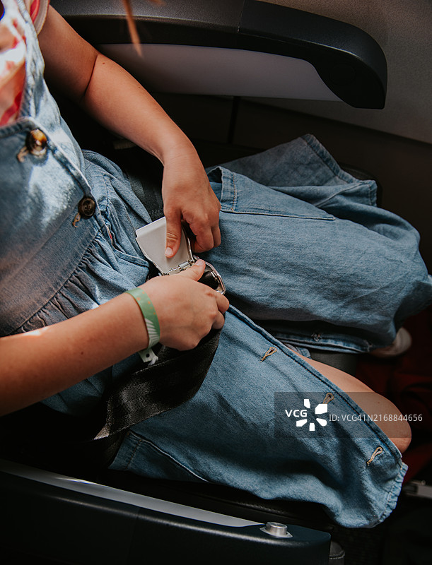 孩子在飞机上解开安全带图片素材
