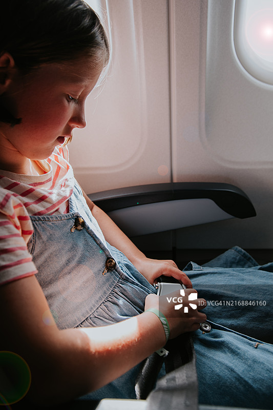 儿童在飞机上系安全带图片素材