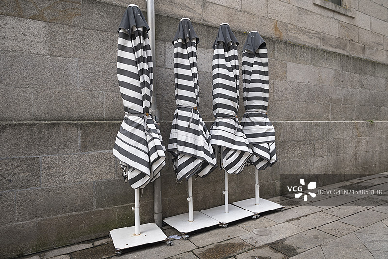 墙边的折叠条纹伞图片素材