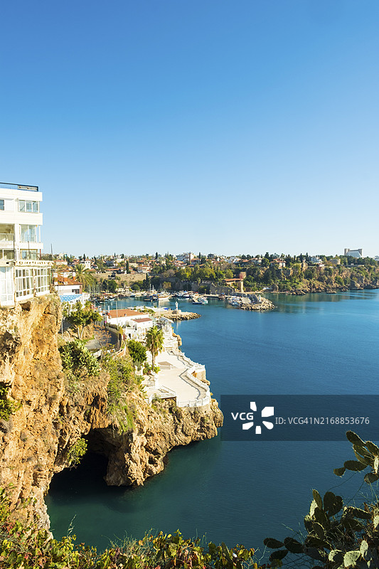 土耳其安塔利亚，从亚武兹·奥兹坎公园看到的海蚀洞入口，背景是海港（竖版）图片素材