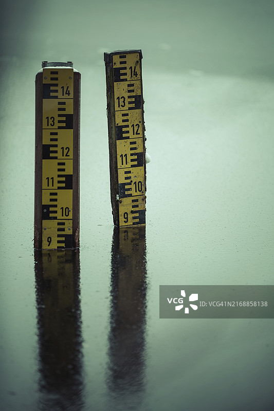 近乎冰冻的湖面上的两个水位指示器图片素材