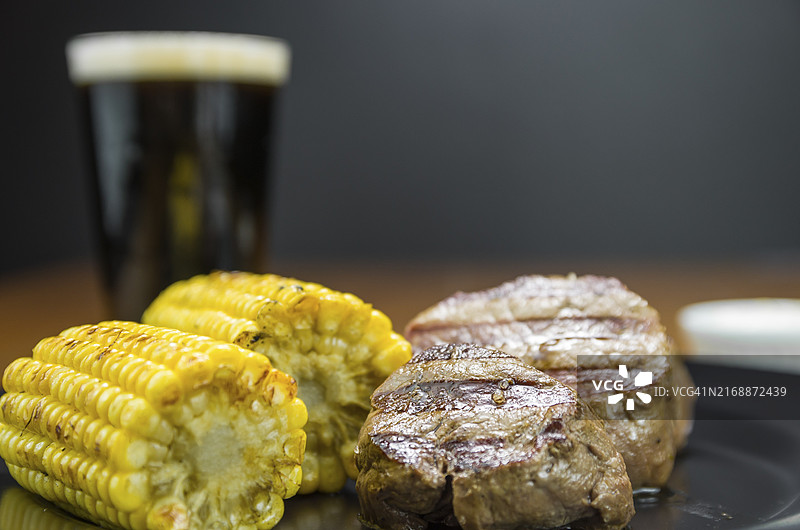 烤玉米佐菲力牛排特写和一杯啤酒图片素材