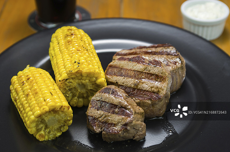 烤玉米佐菲力牛排特写和一杯啤酒图片素材