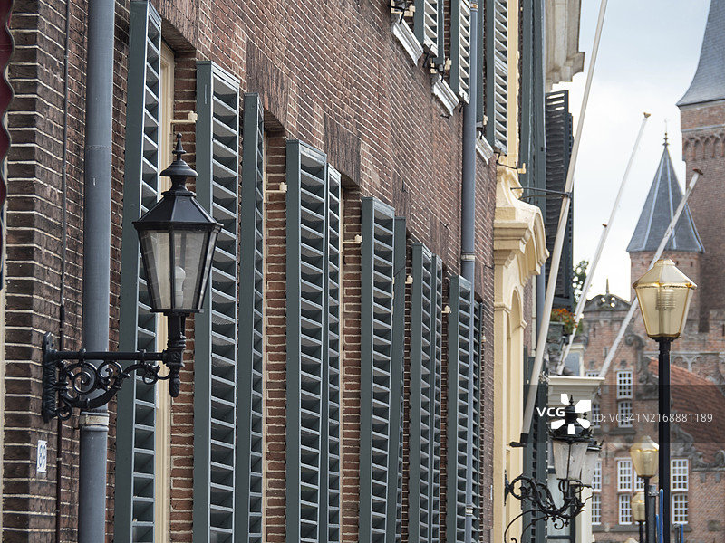 荷兰聚特芬的窄巷，配有老式灯笼和绿色百叶窗装饰的建筑图片素材