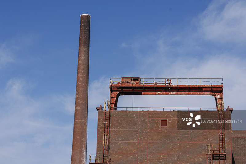砖砌工业建筑，背景是高大的烟囱和淡蓝色天空，德国埃森鲁尔区图片素材