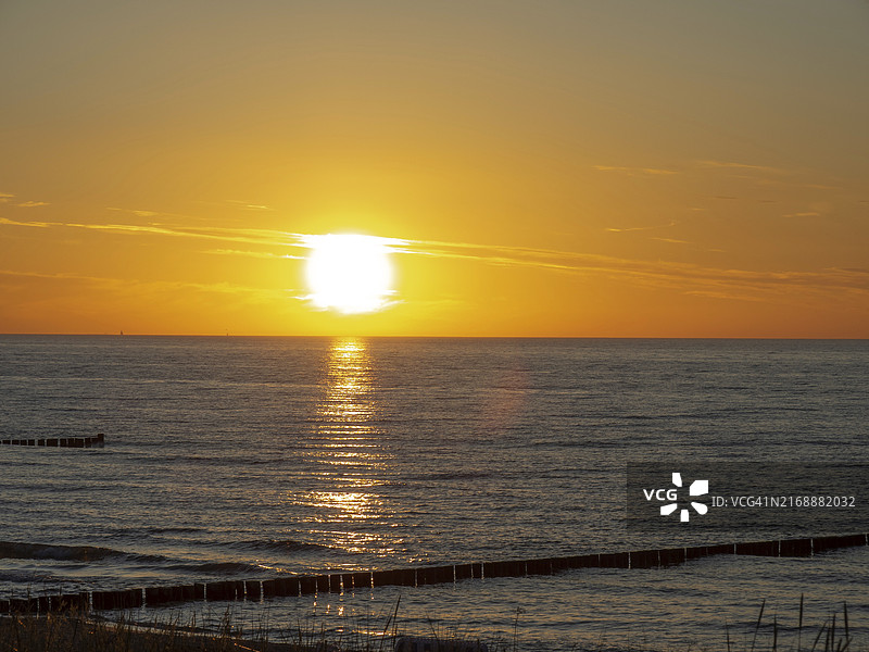 德国波罗的海：阿伦斯霍普，青斯特，海面上的平静日落，天空与水面被染成橙色图片素材