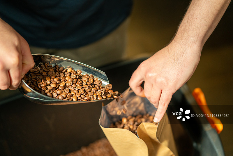 男人正在包装准备出售的烘焙咖啡豆图片素材