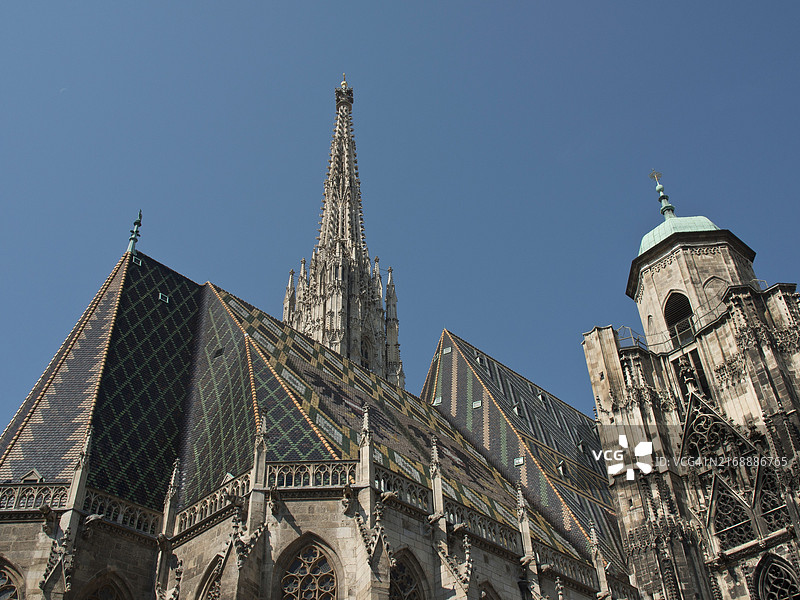 维也纳圣斯蒂芬大教堂塔楼和屋顶的宽阔视野，蓝色天空下引人注目的图案，奥地利，欧洲图片素材