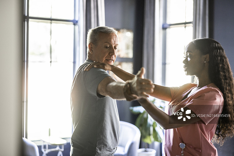 家中医护人员为老年男人进行物理治疗图片素材