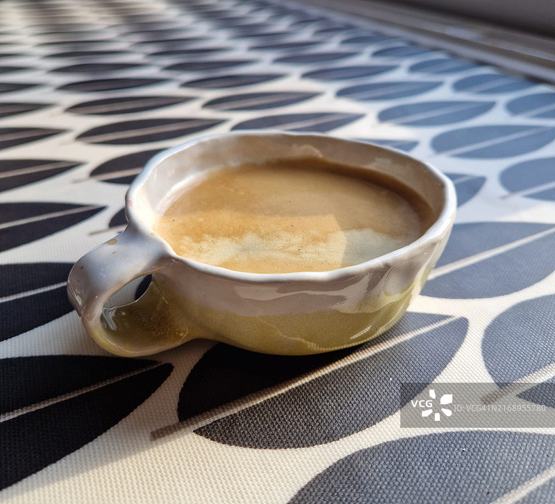 在家用桌子上制作的扁平宽口杯中的浓缩咖啡图片素材