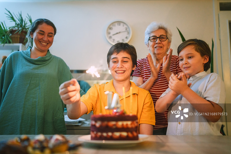 14岁男孩与家人在家庆祝生日图片素材