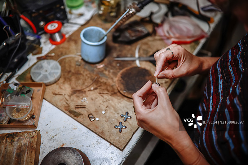 中年妇女在工作室制作陶瓷金属首饰特写图片素材