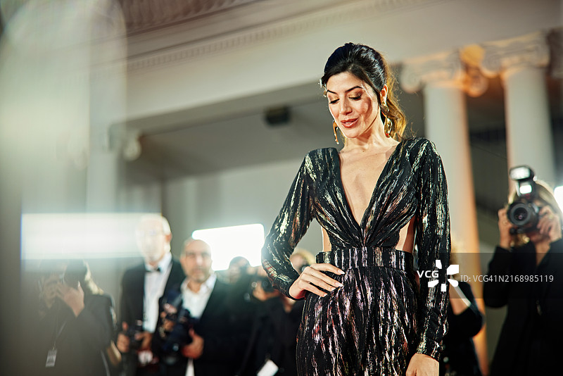 女名人在活动中被拍摄，手放在臀部图片素材