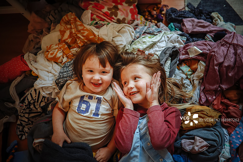孩子们玩成一堆衣服；兄妹情深，嬉戏打闹，一起整理图片素材