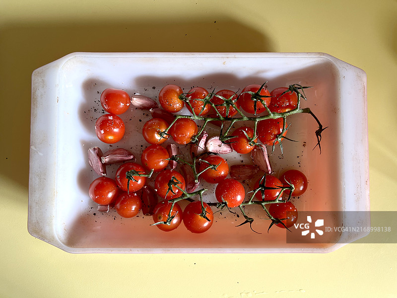 准备入烤箱的圣女果和大蒜图片素材