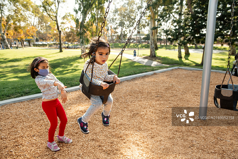 姐妹在公园荡秋千图片素材