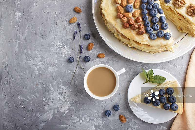 自制拿破仑蛋糕与牛奶奶油，蓝莓、杏仁、核桃、榛子、薄荷装饰，灰色背景，俯视拍摄图片素材