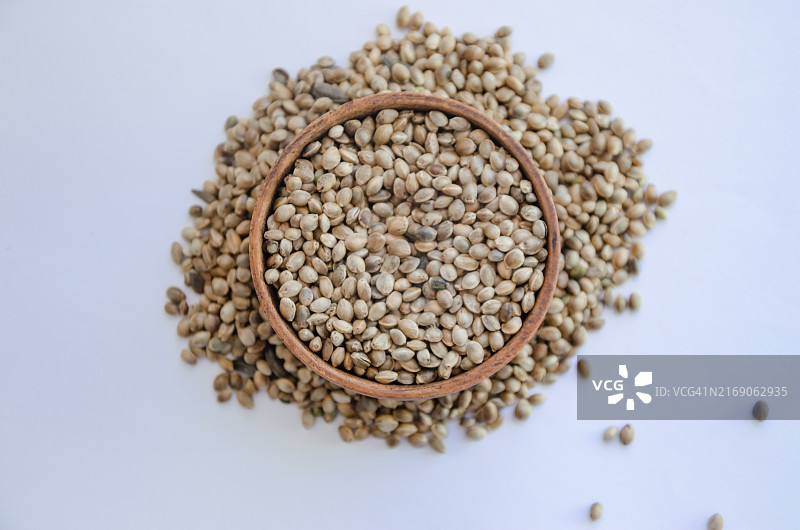 白色背景木盘中的大麻籽图片素材