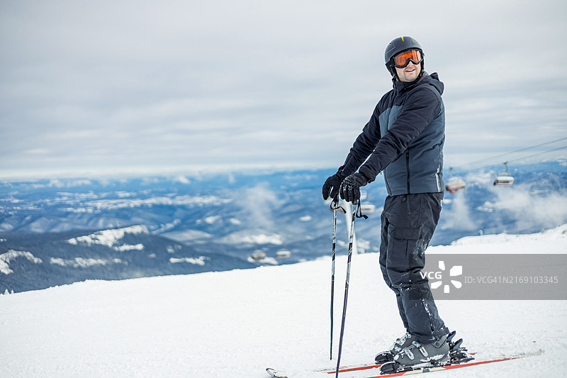 站在白雪皑皑的山顶斜坡上滑雪的人图片素材