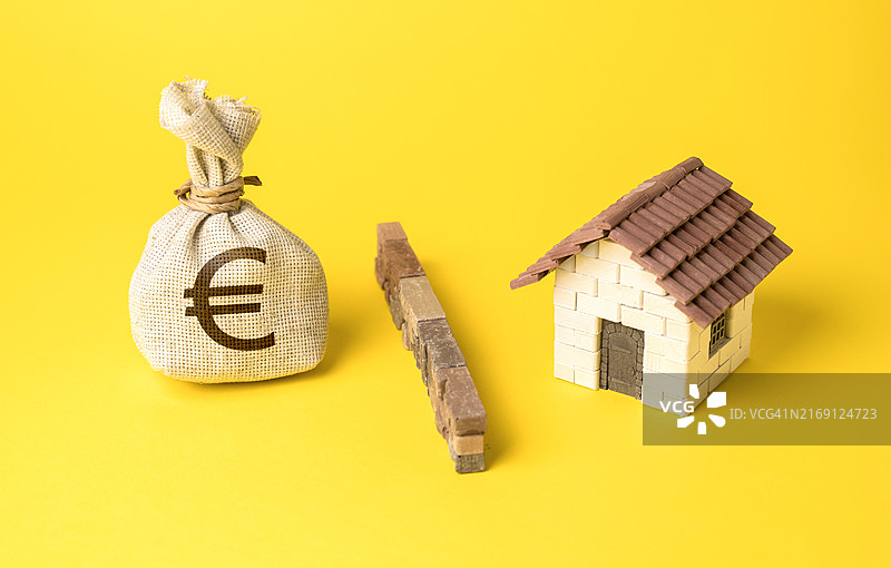 黄色背景上带有模型房屋和黄色丝带的模型房屋高角度视图图片素材